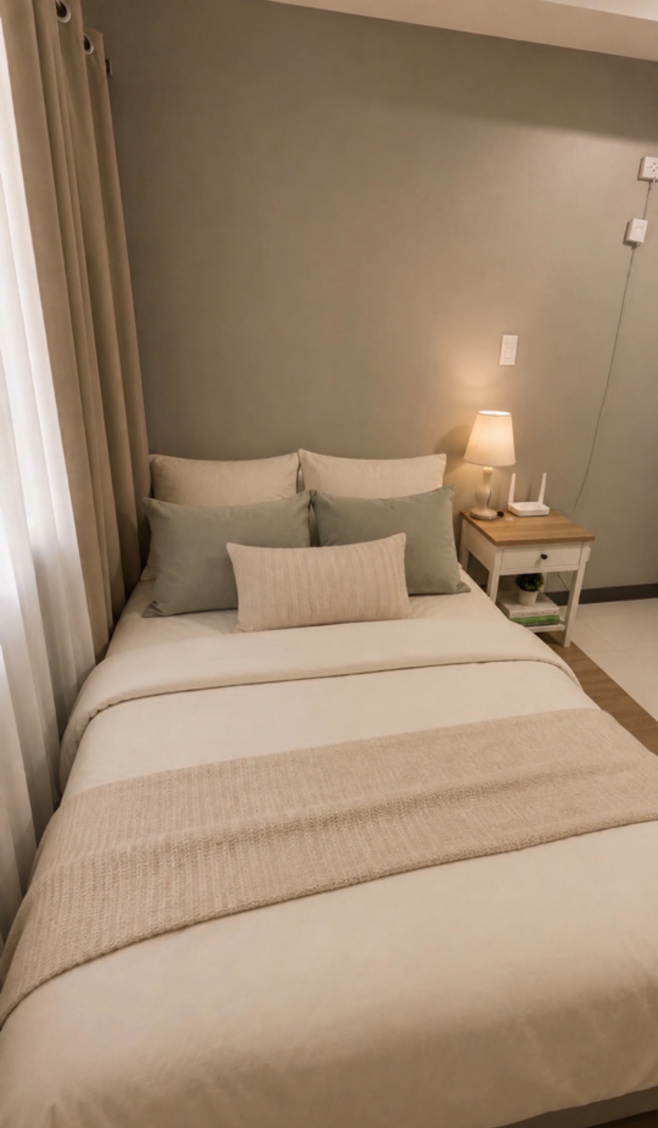 Double bed with sage cushions beside the bedside lamp
