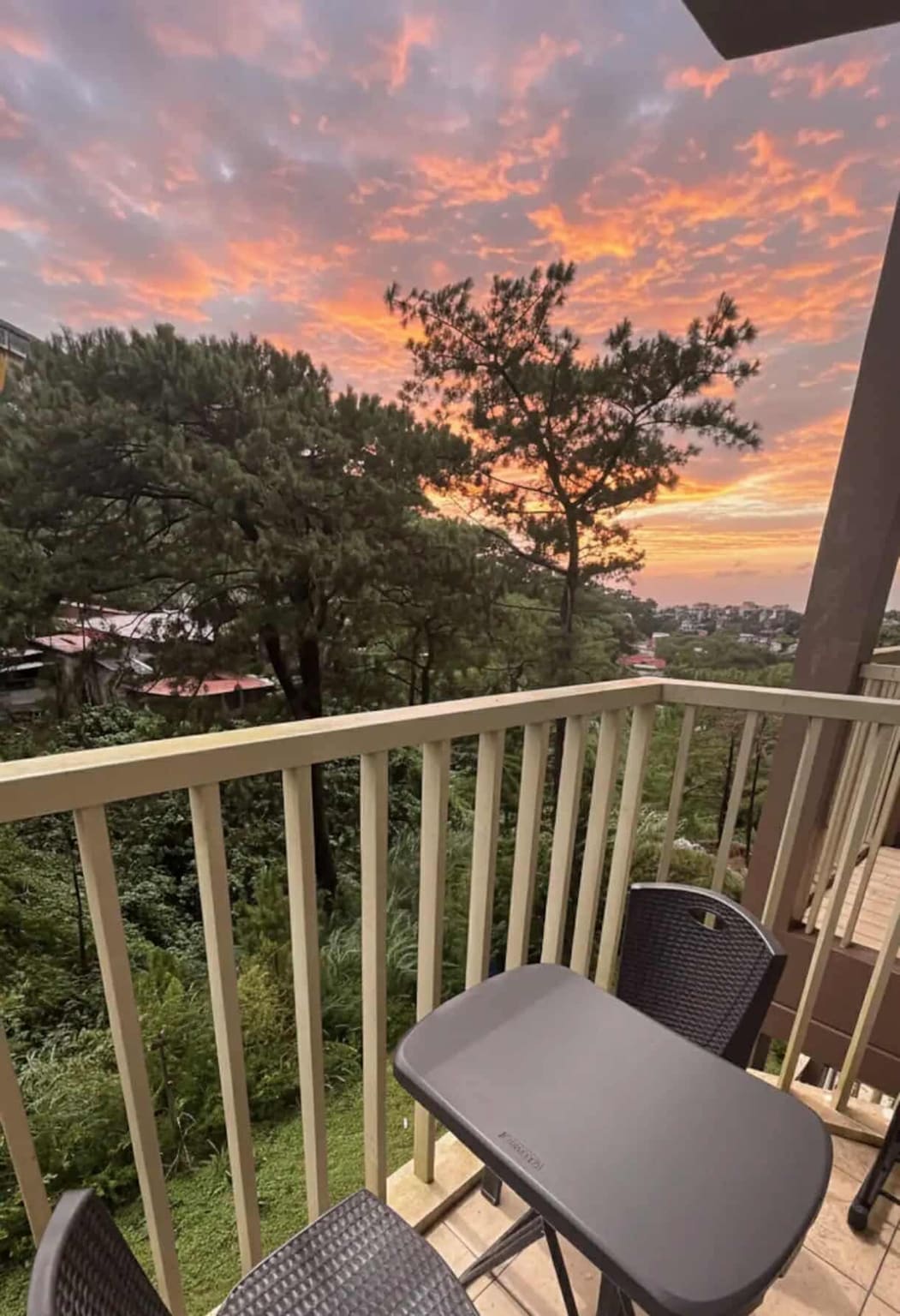 Balcony table and chairs looking over the pines at sunset
